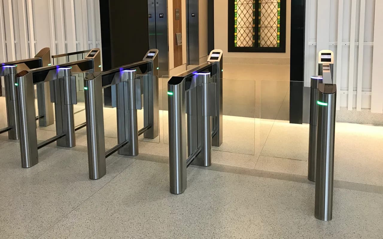 Rangée de portillons de contrôle d'accès à lecteur, dans le hall d'un immeuble.
